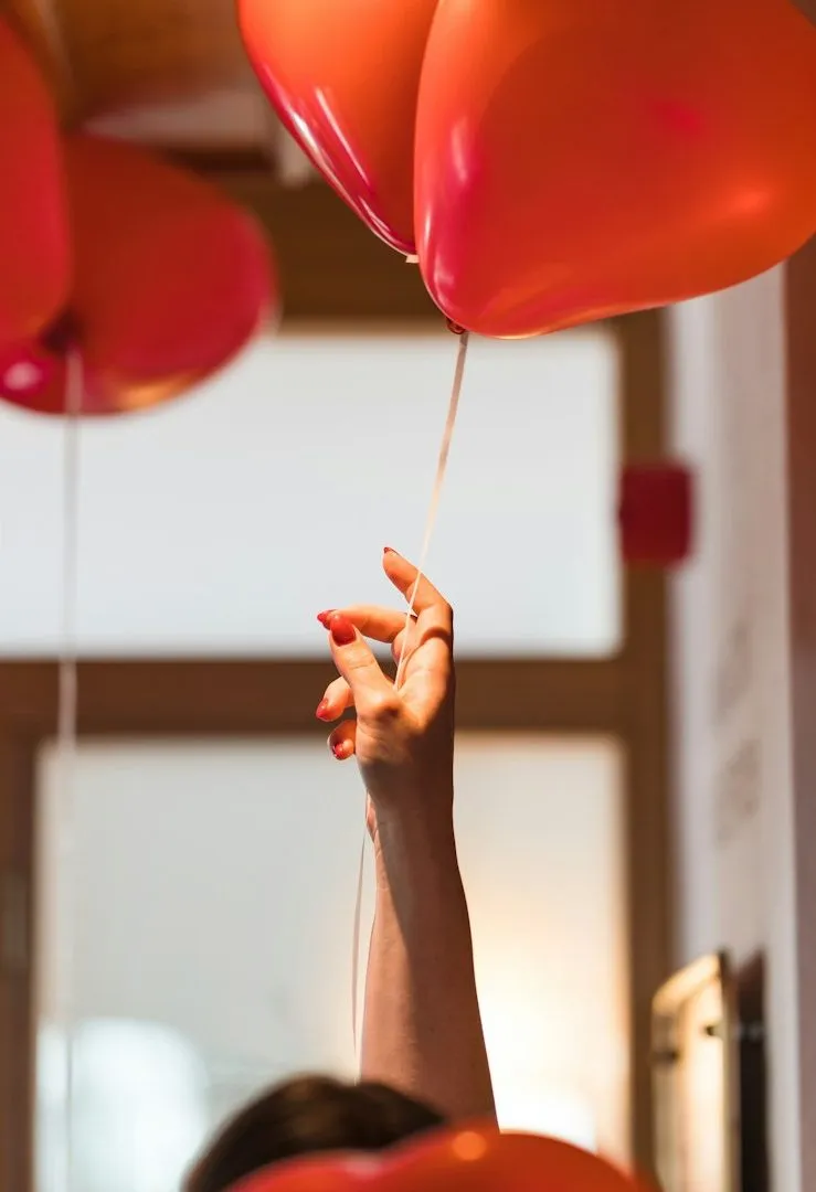 Eine geöffnete Hand hält einen kleinen, sandfarbenen Ballon, der ruhig in der Luft schwebt — Sinnbild dafür, dass jeder Verkauf etwas Bleibendes nach oben trägt.